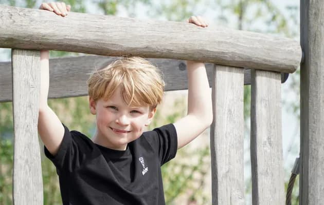 Kind speelt buiten op speeltoestel bij gastouder van kinderopvang Kind&co ludens