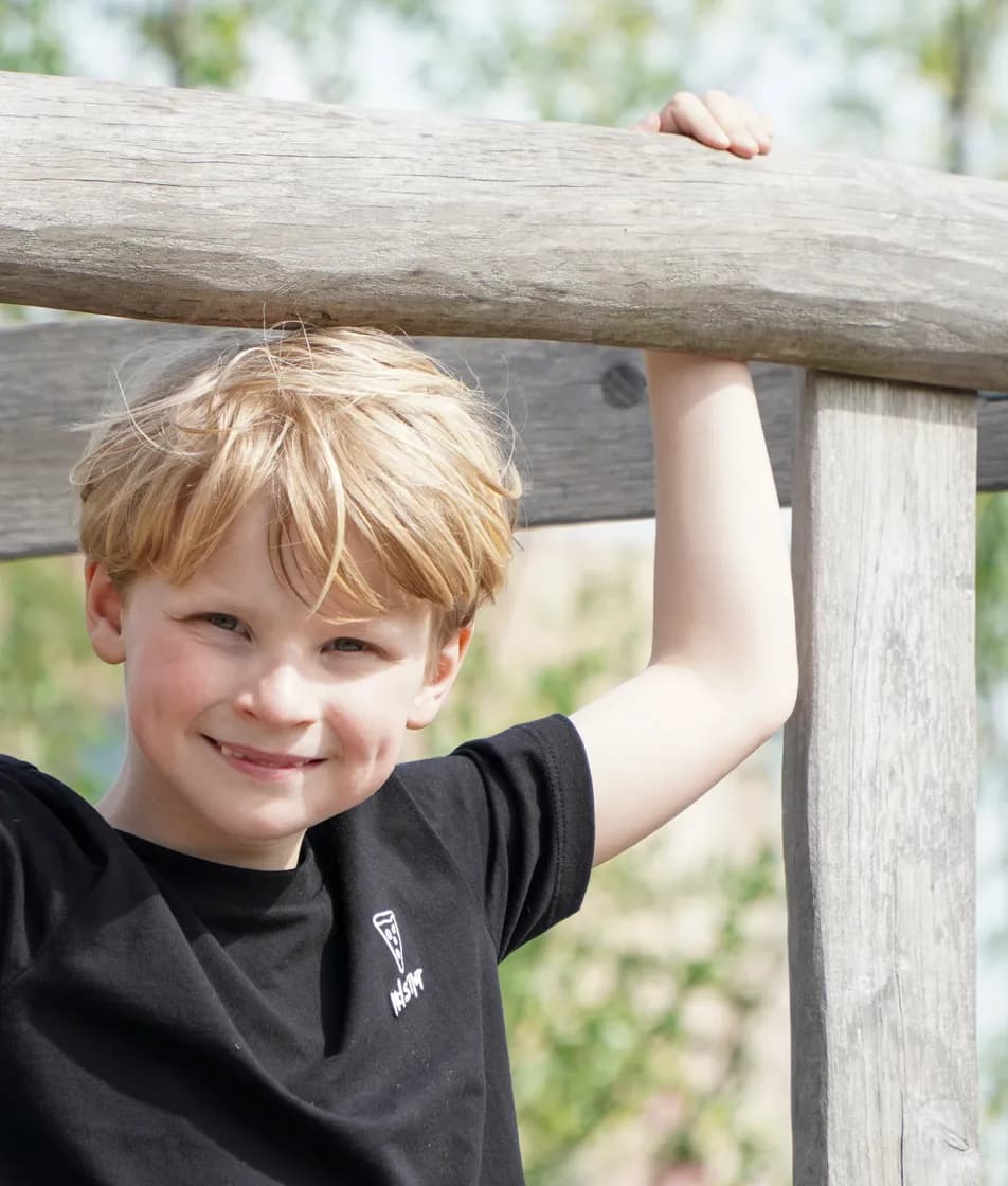 Kind speelt buiten op speeltoestel bij gastouder van kinderopvang Kind&co ludens