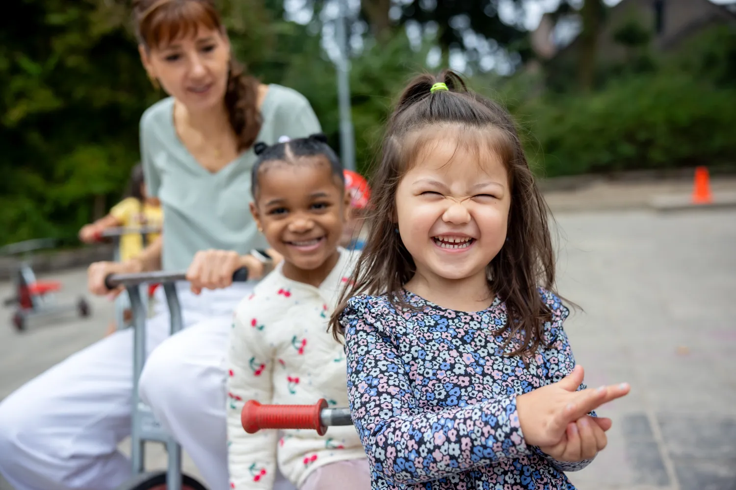 Kinderen spelen buiten met pedagogisch medewerker bij kinderopvang Kind&co ludens