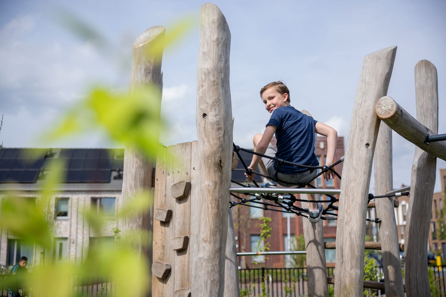 Kind speelt buiten in klimspin bij kinderopvang Kind&co ludens