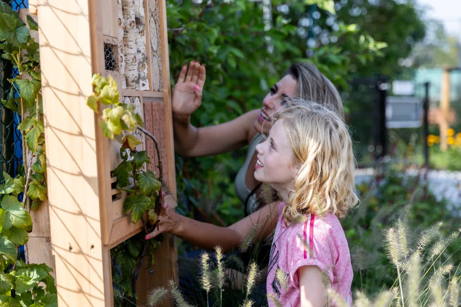 Kind speelt buiten met pedagogisch medewerker bij kinderopvang Kind&co ludens