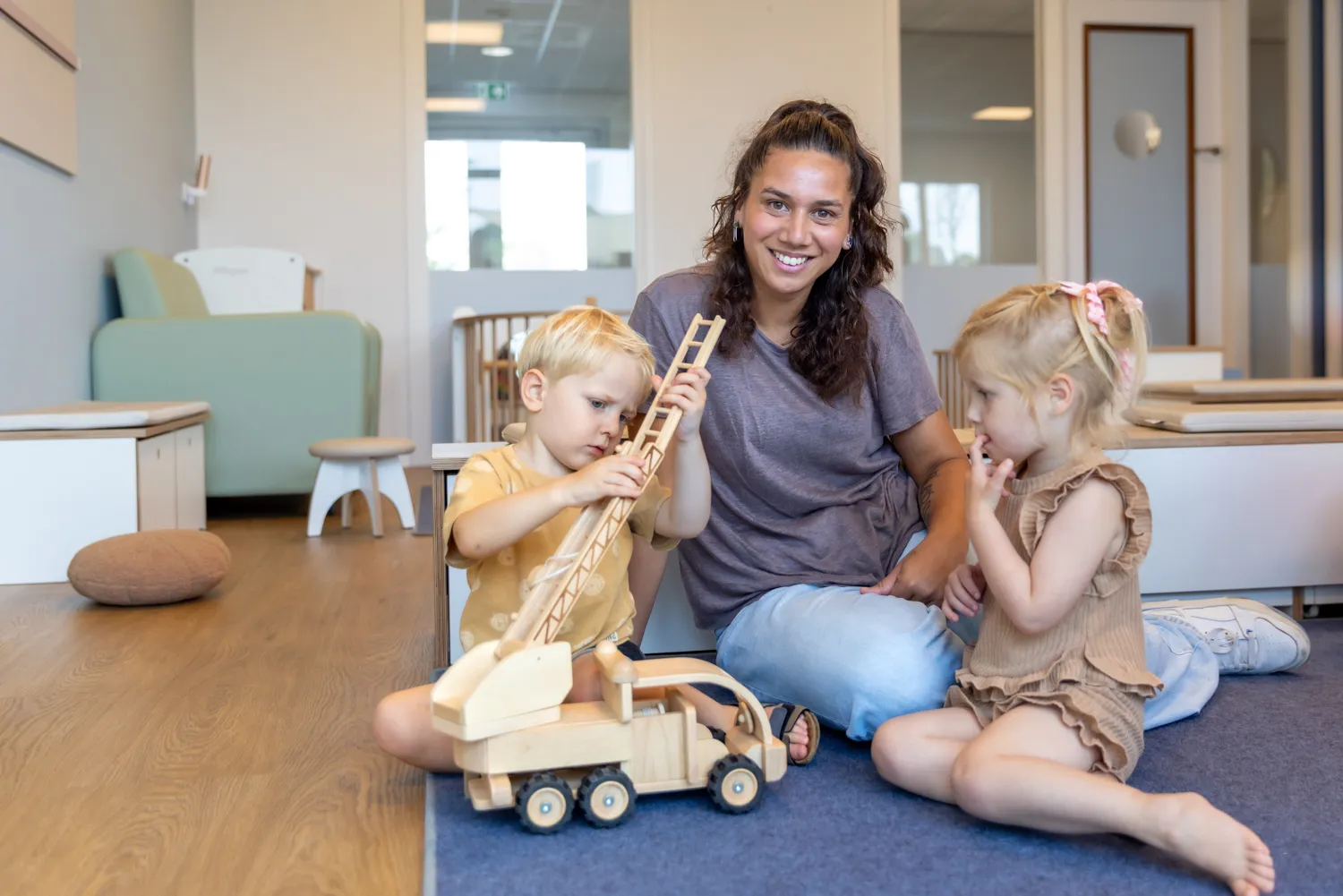 Kinderen spelen samen met pedagogisch medewerker bij kinderopvang Kind&co ludens