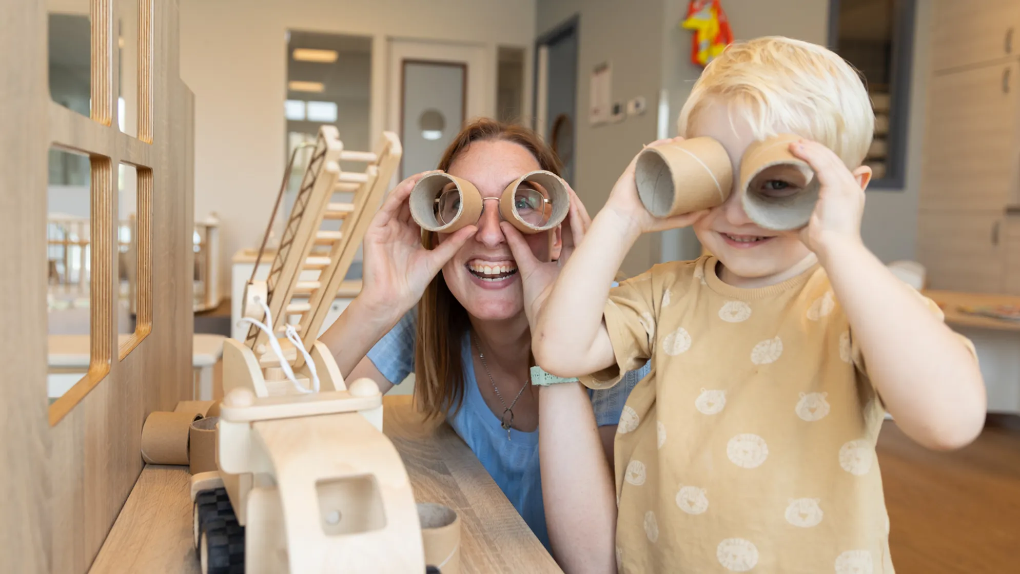 Kind speelt met wc rollen met pedagogisch medewerker bij kinderopvang Kind&co ludens