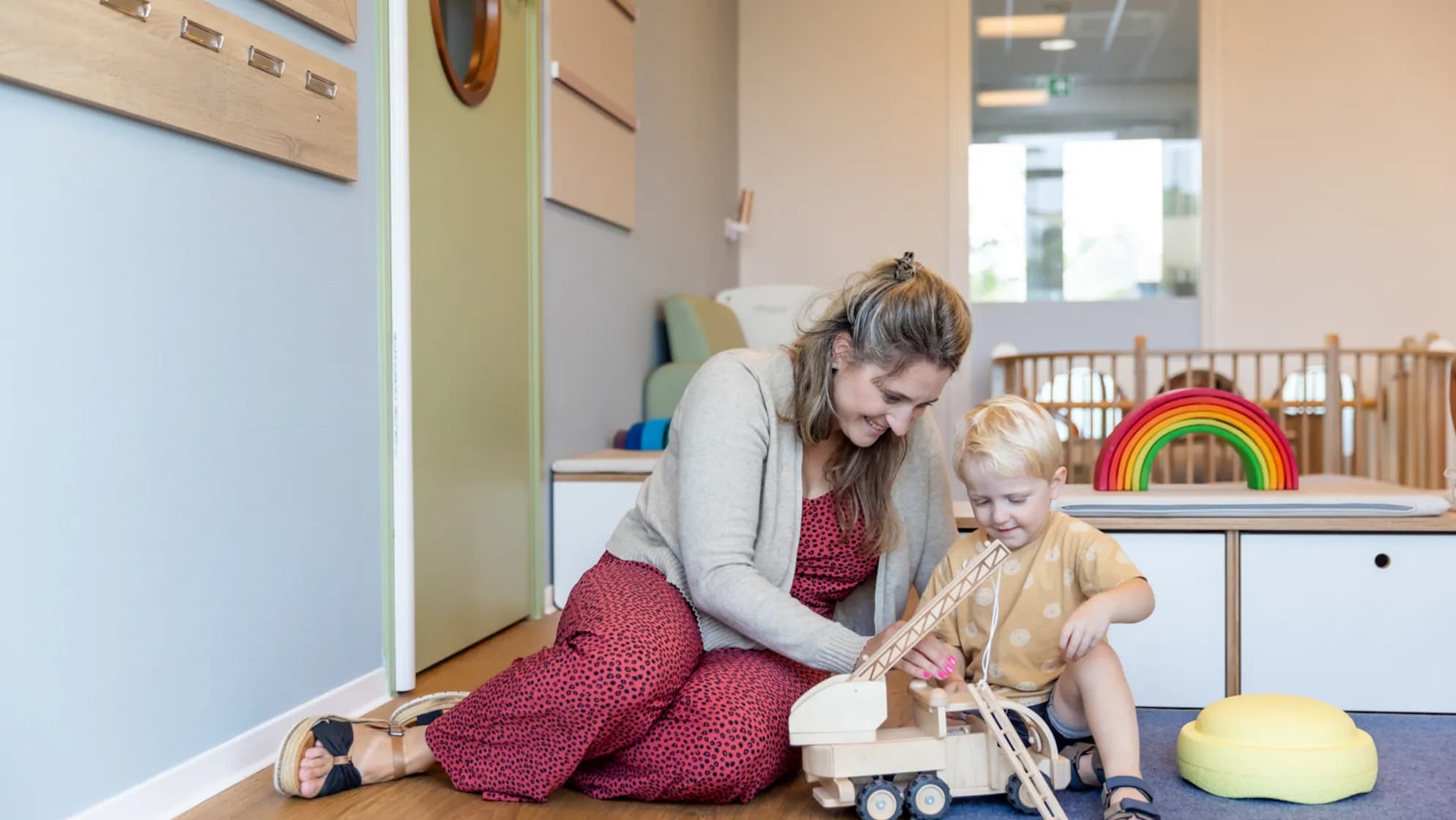 Kinderen spelen samen met pedagogisch medewerker bij kinderopvang Kind&co ludens