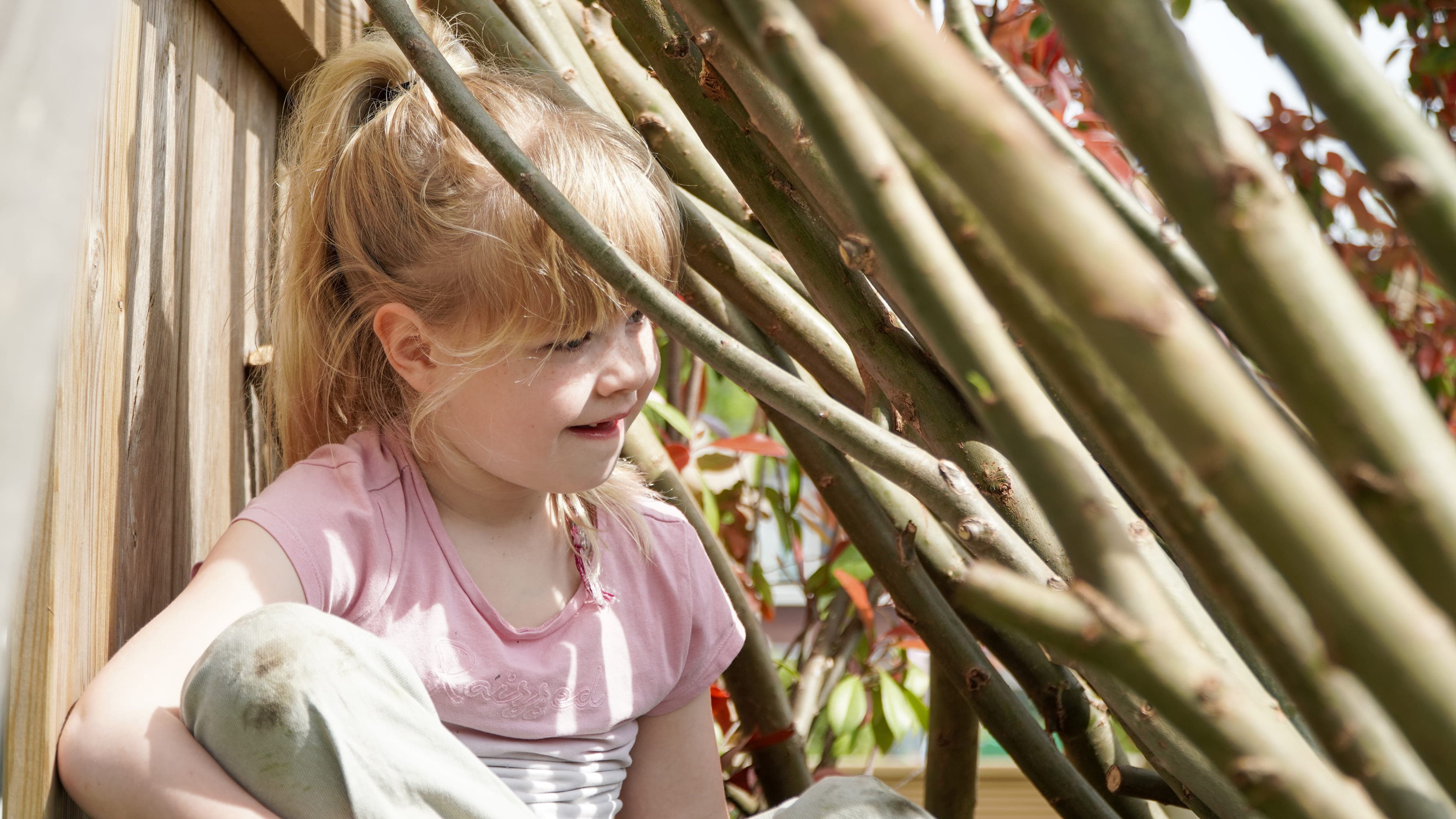 Kind speelt buiten in Wilgentakken huisje bij gastouder van kinderopvang Kind&co ludens