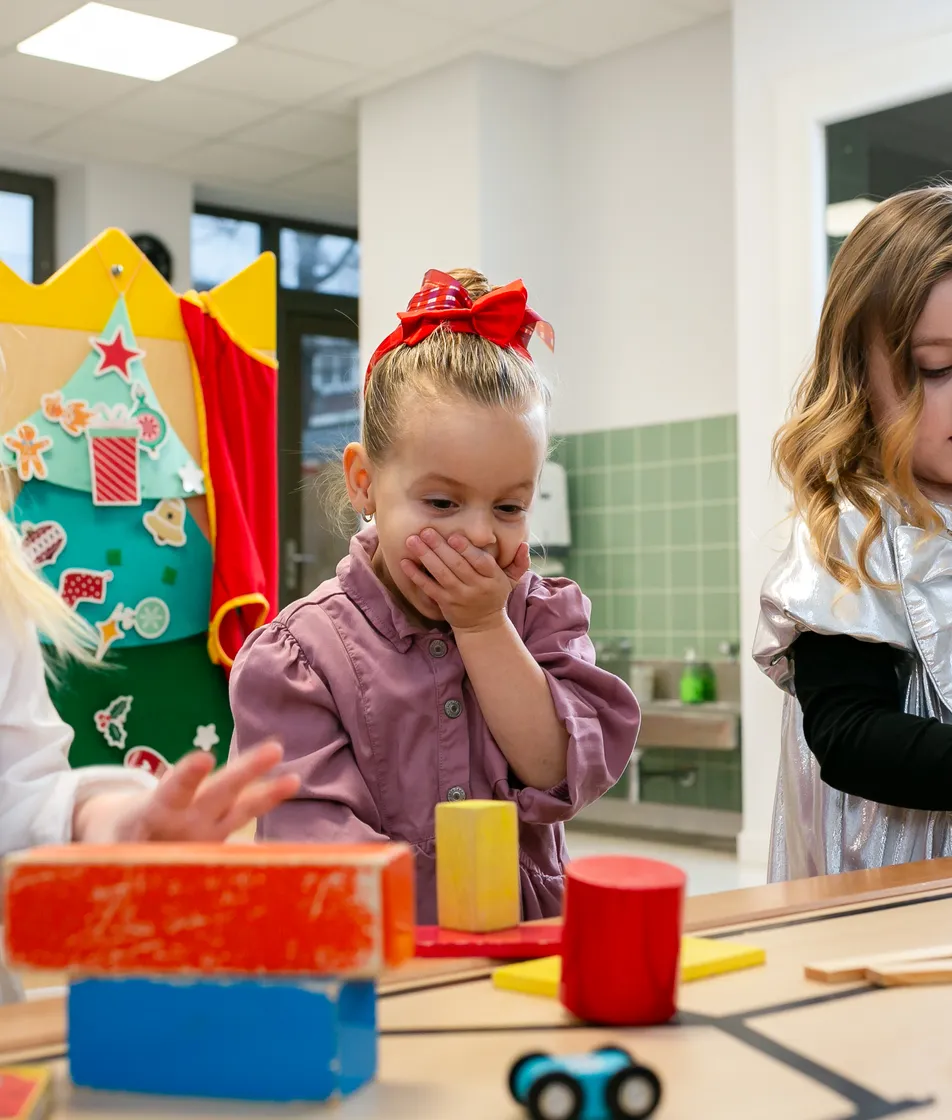 Kinderen van de peutergroep lachen en spelen samen bij kinderopvang Kind&co ludens