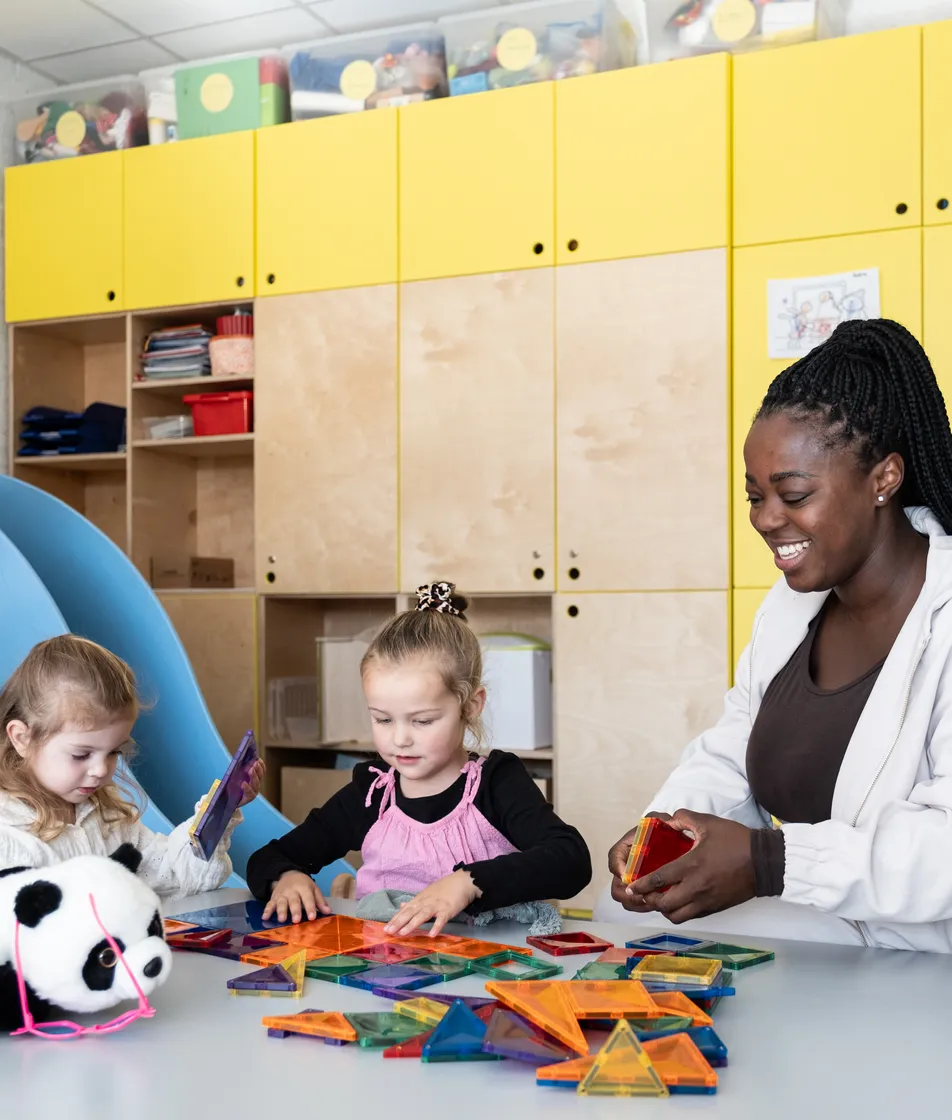 Pedagogisch medewerker is aan het knutselen met kinderen