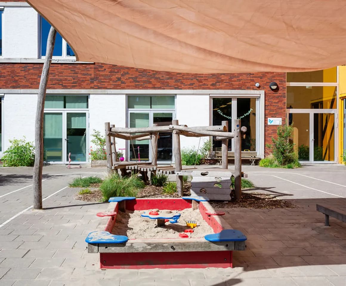 De buitenruimte met zandbak peuteropvang de Olijfboom, kinderopvang Kind&co Ludens