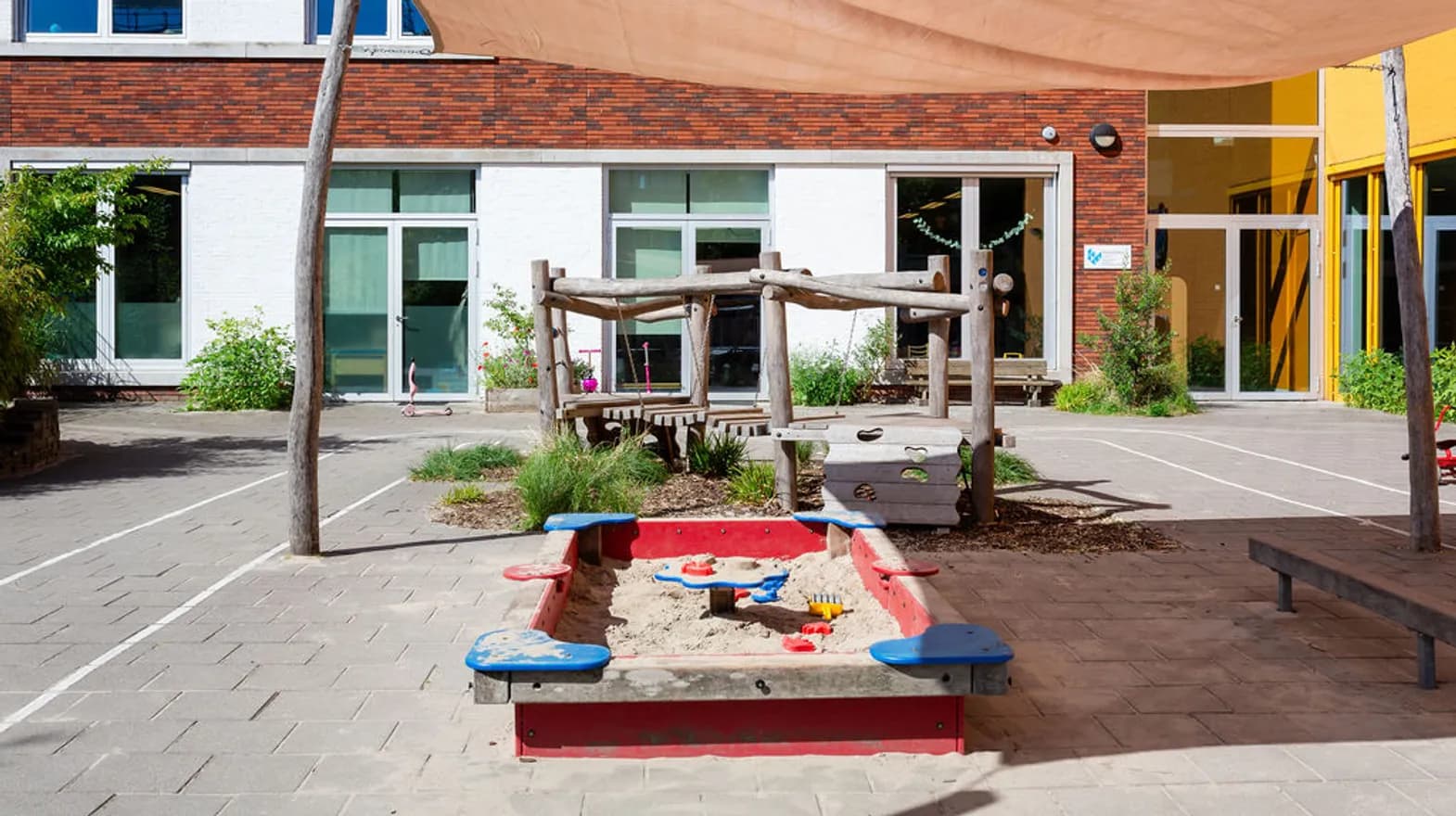 De buitenruimte met zandbak peuteropvang de Olijfboom, kinderopvang Kind&co Ludens