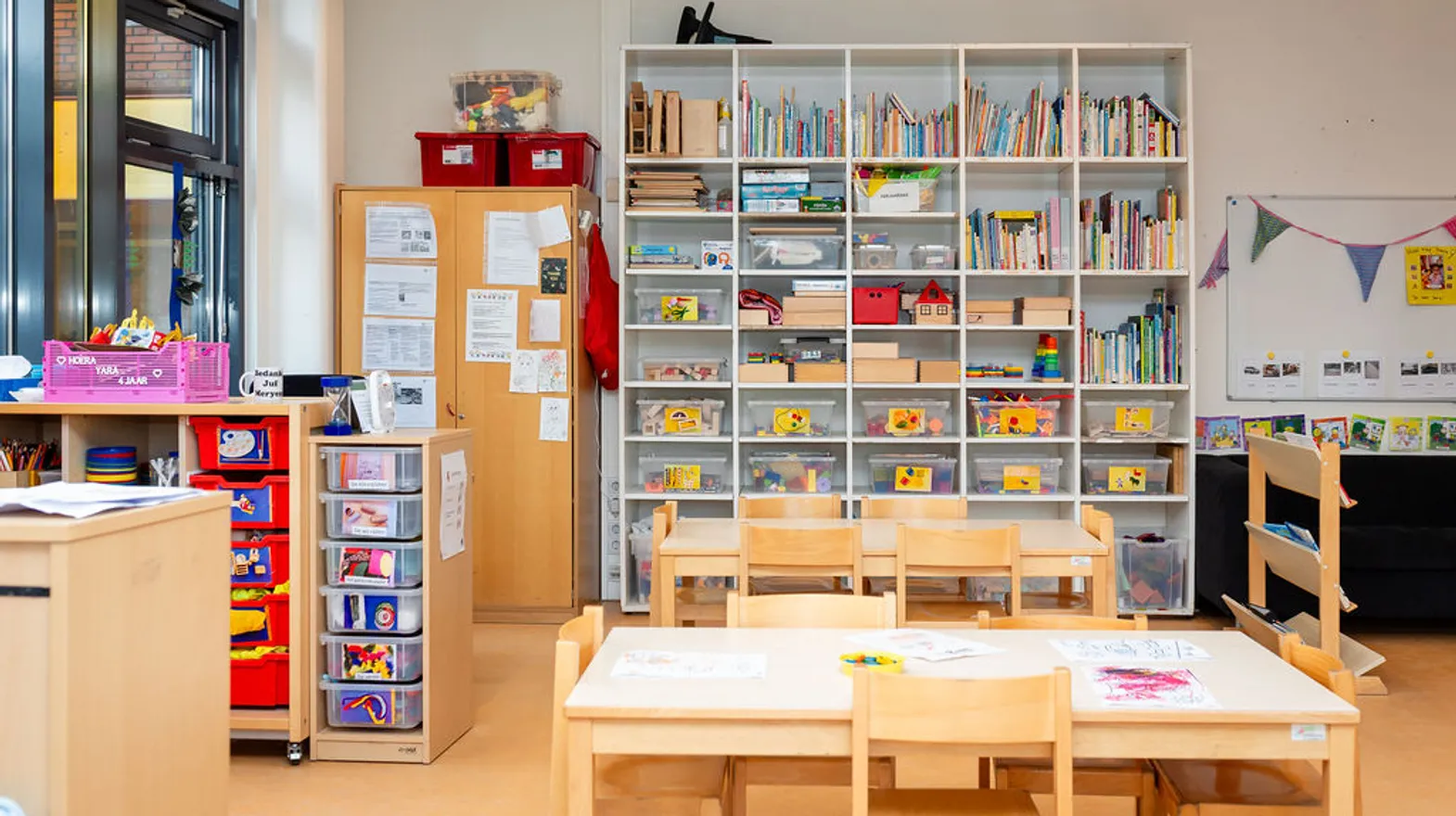 De groepsruimte met verschillende speelhoeken en grote kast met speelmateriaal bij peuteropvang Schateiland bij kinderopvang Kind&co Ludens