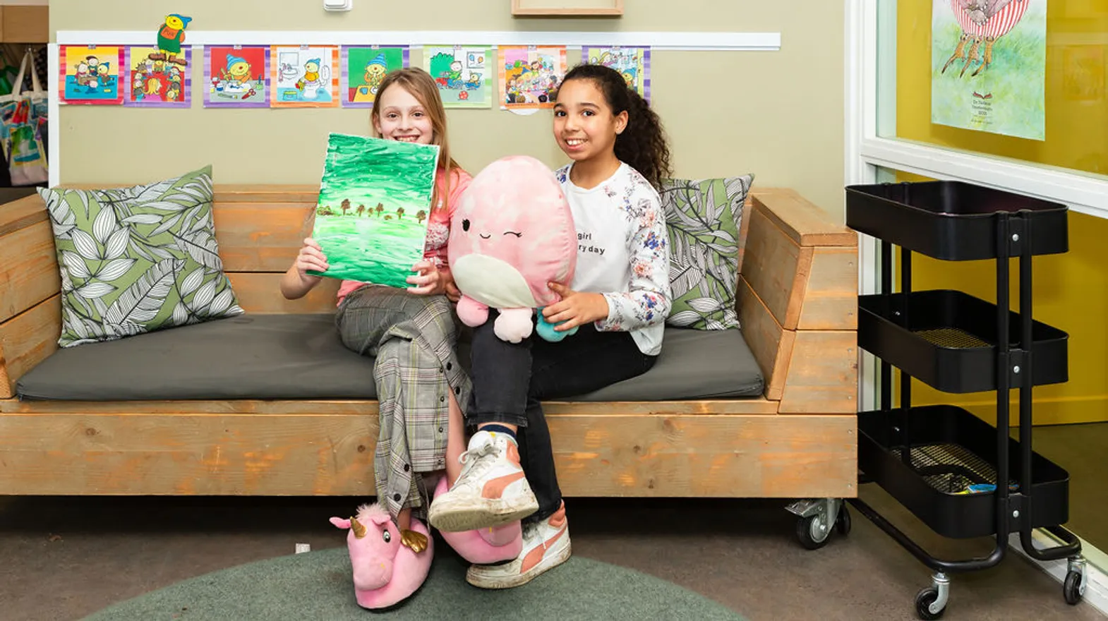 Kinderen laten leesboek en knuffel zien bij buitenschoolse opvang IJsbeer, kinderopvang Kind&co ludens