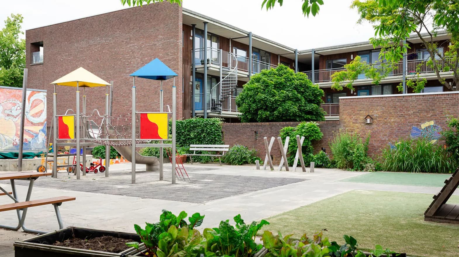 Het speelplein met zandbak en klimtoestel bij buitenschoolse opvang de Jutter, kinderopvang Kind&co Ludens