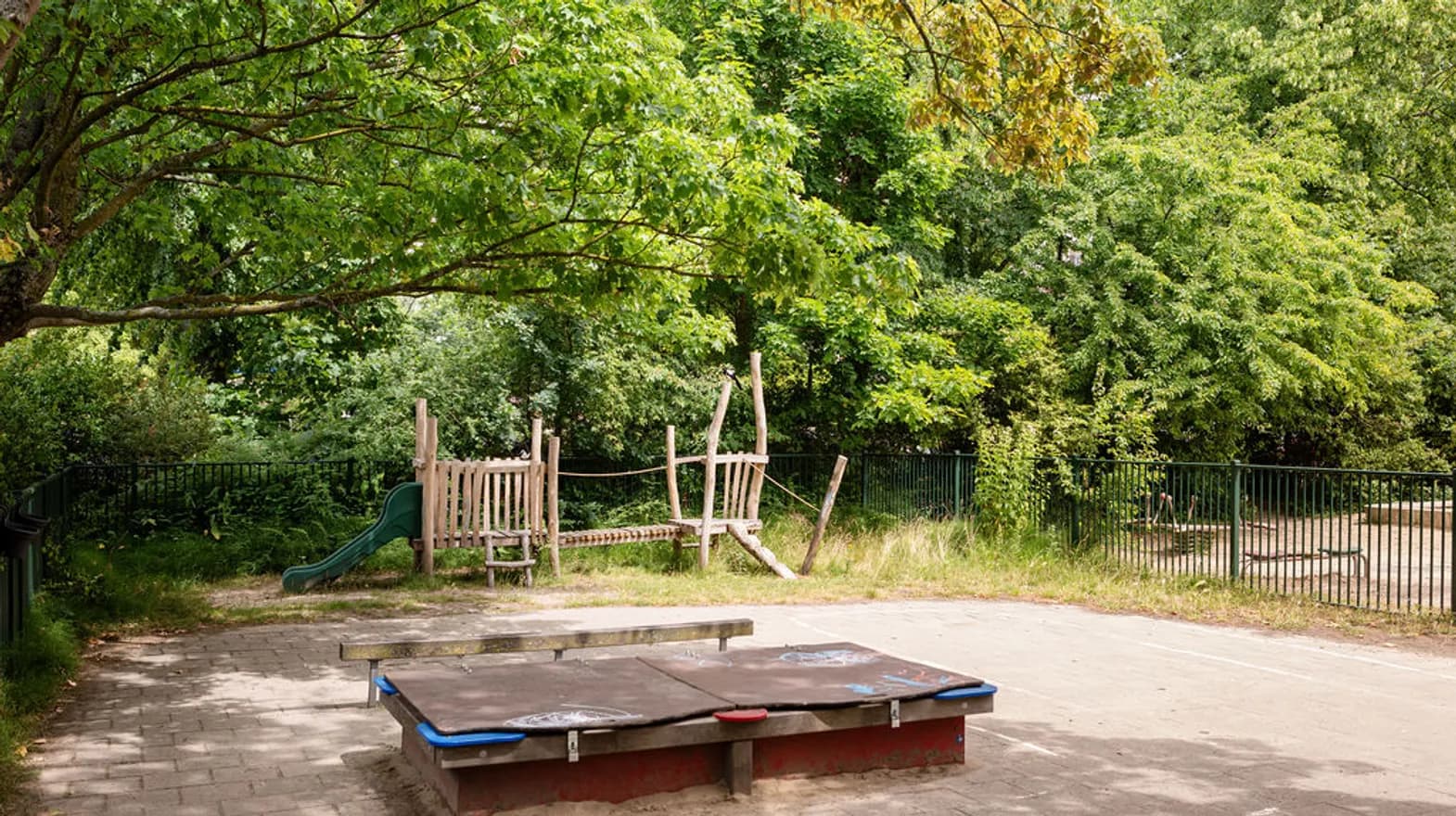 Het houten klimtoestel en zandbak in de tuin van peuteropvang Puk, kinderopvang Kind&co Ludens