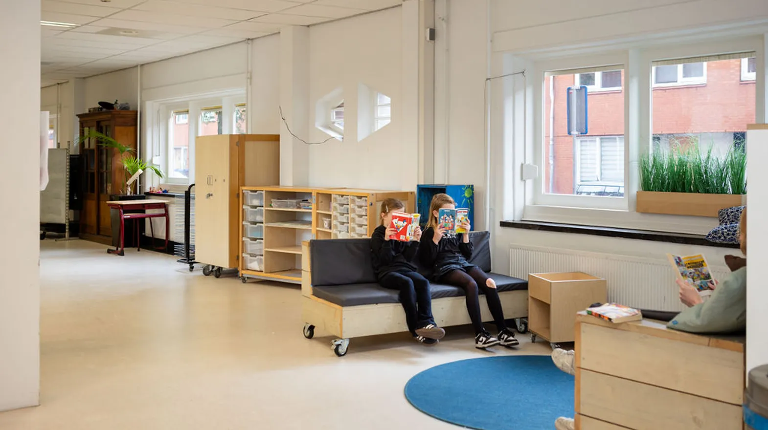 Kinderen lezen een boek in de chillhoek bij buitenschoolse opvang Dwars, kinderopvang Kind&co ludens