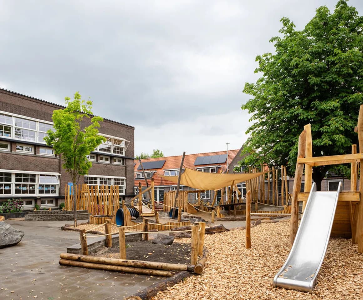 Het speelplein met houten klimtoestel in de tuin van buitenschoolse opvang Rijmgeheim, kinderopvang Kind&co Ludens