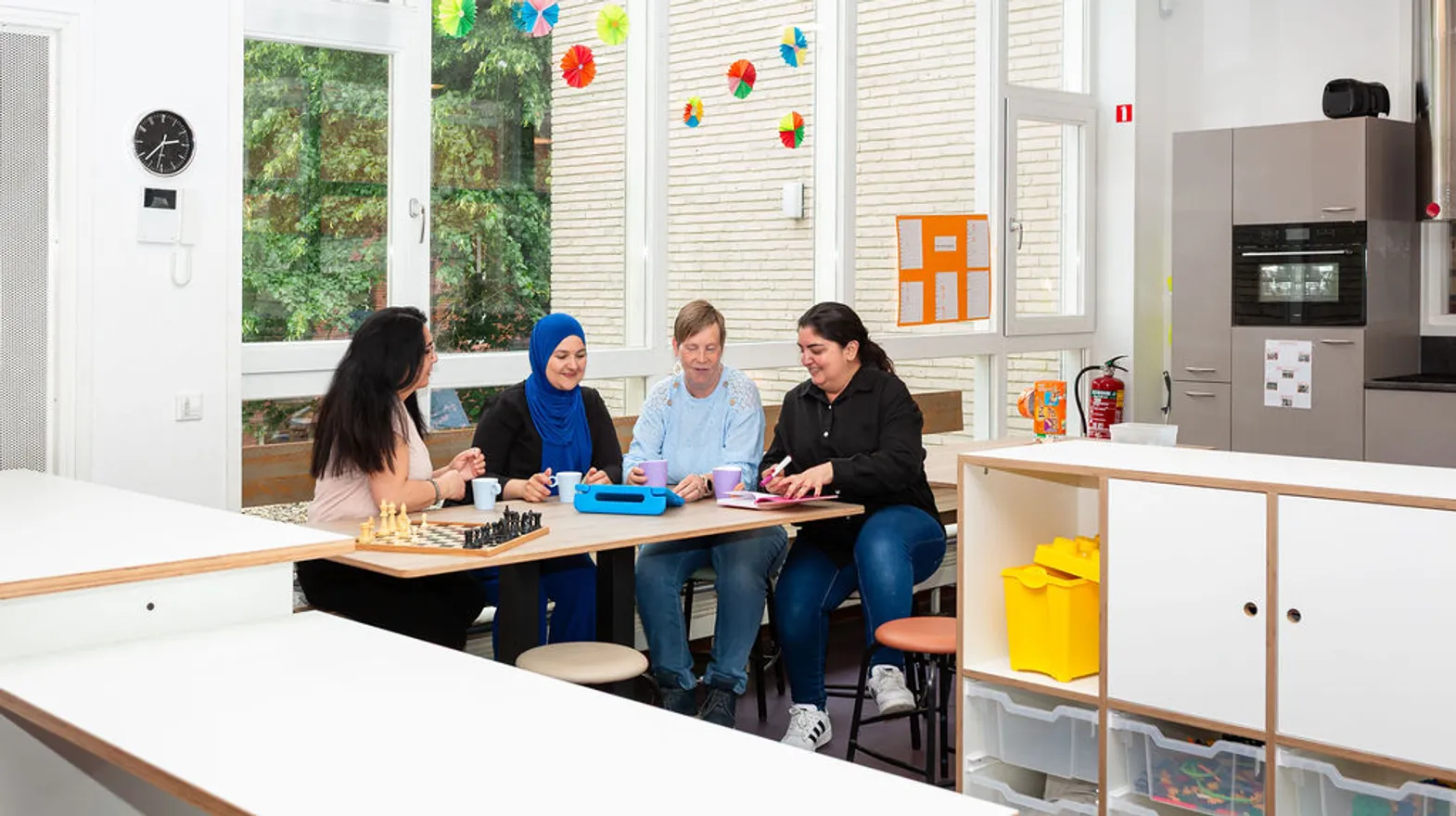 Pedagogisch medewerkers nemen de dag door bij buitenschoolse opvang Troubadour, kinderopvang Kind&co Ludens