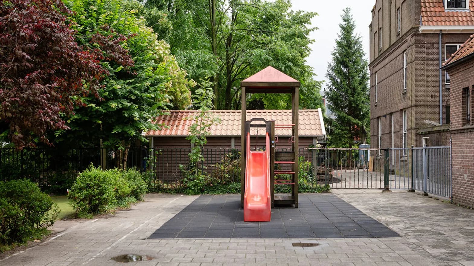 De tuin met glijbaan bij buitenschoolse opvang Dwars, kinderopvang Kind&co ludens