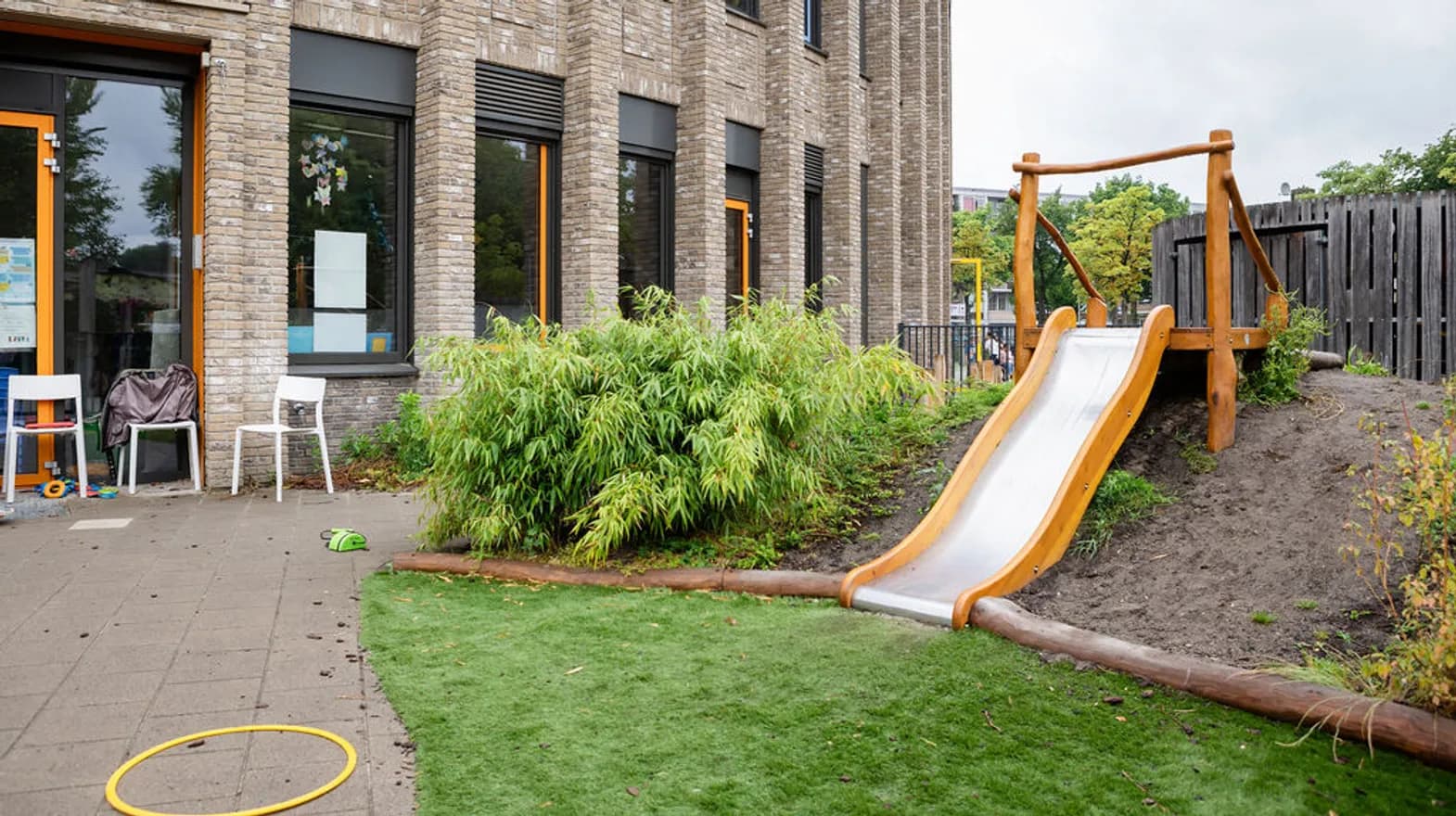 Het glijbaan en speelheuvel in de tuin van peuteropvang Teun bij kinderopvang Kind&co Ludens