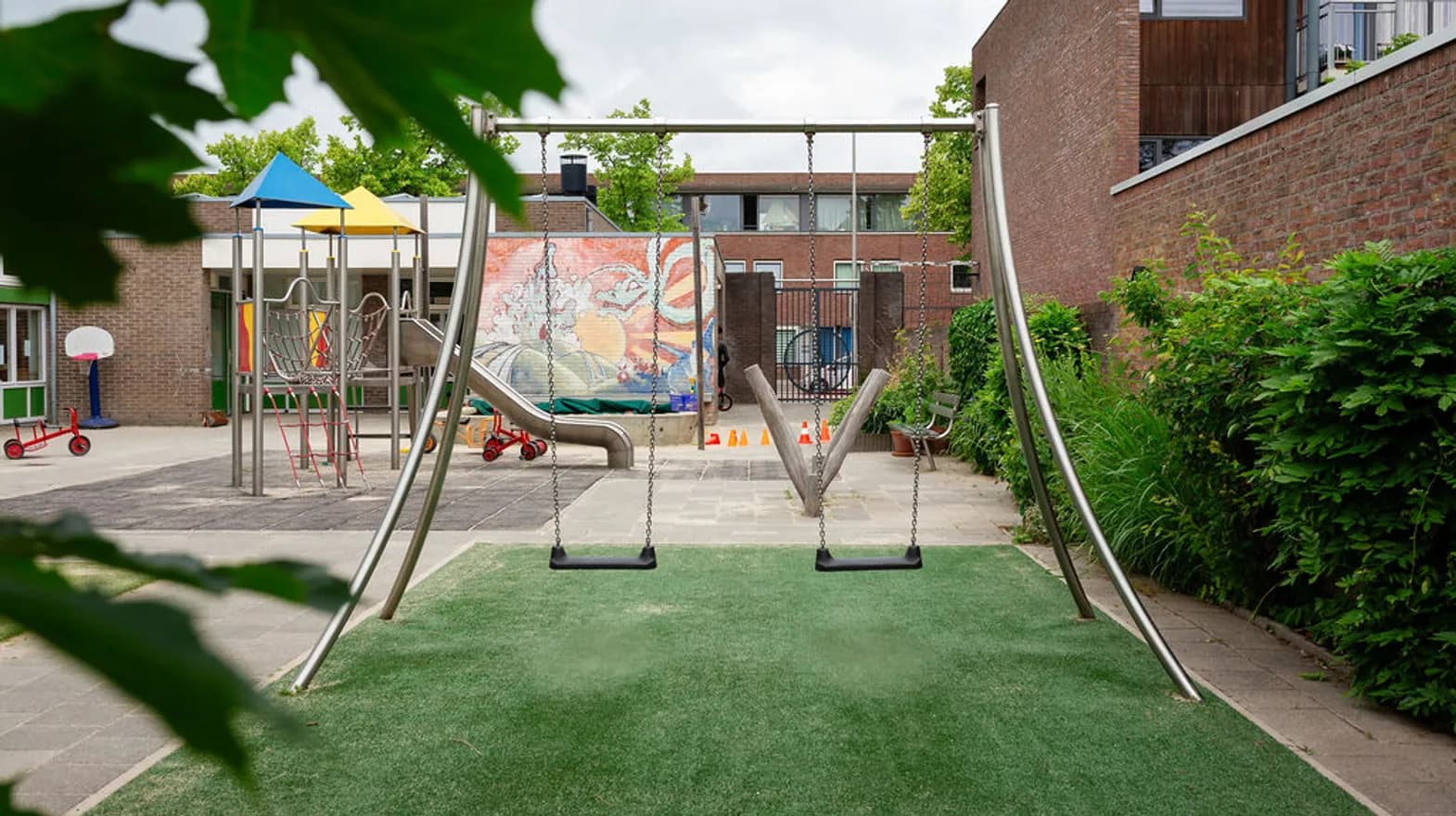 De buitenruimte met schommels bij peuteropvang de Blokkendoos, kinderopvang Kind&co Ludens