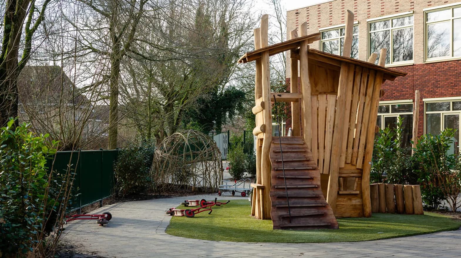 De ontdek tuin met houten speeltoestel bij kinderdagverblijf de Triangel, kinderopvang Kind&co Ludens
