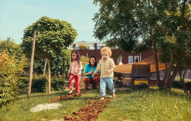 Kinderen lopen over een blotevoetenpad bij Kind&co ludens