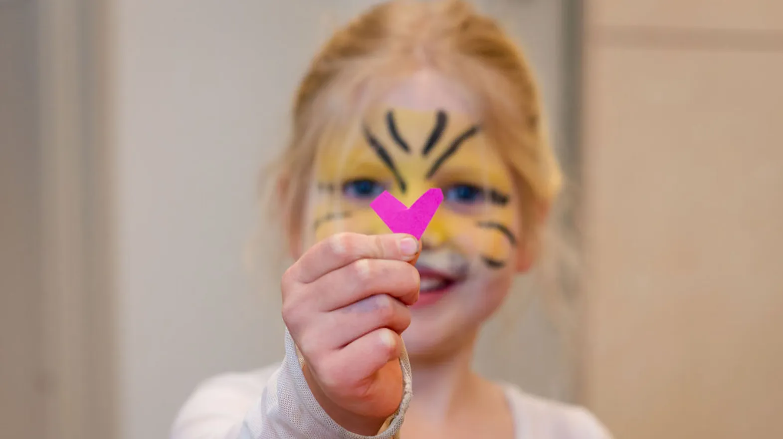 Kind laat geknipt hartje zien van papier bij BSO Kikkersloot van Kind&co ludens