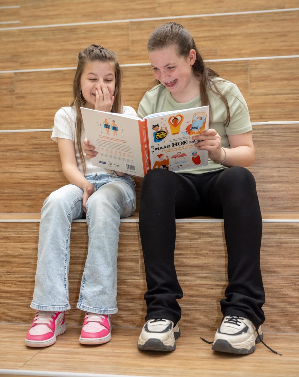 Kinderen lezen samen een grappig boek bij kinderopvang Kind&co ludens