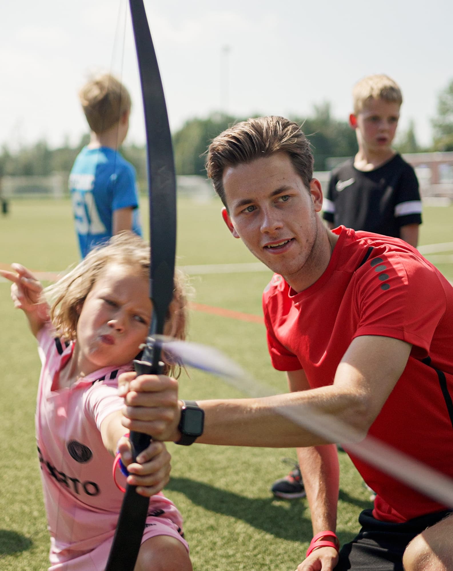 Collega leert kind boogschieten op de BSO