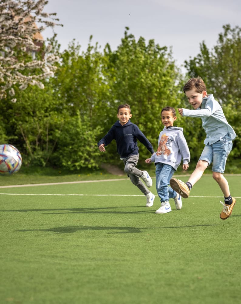 Kinderen voetballen bij kinderopvang Kind&co ludens