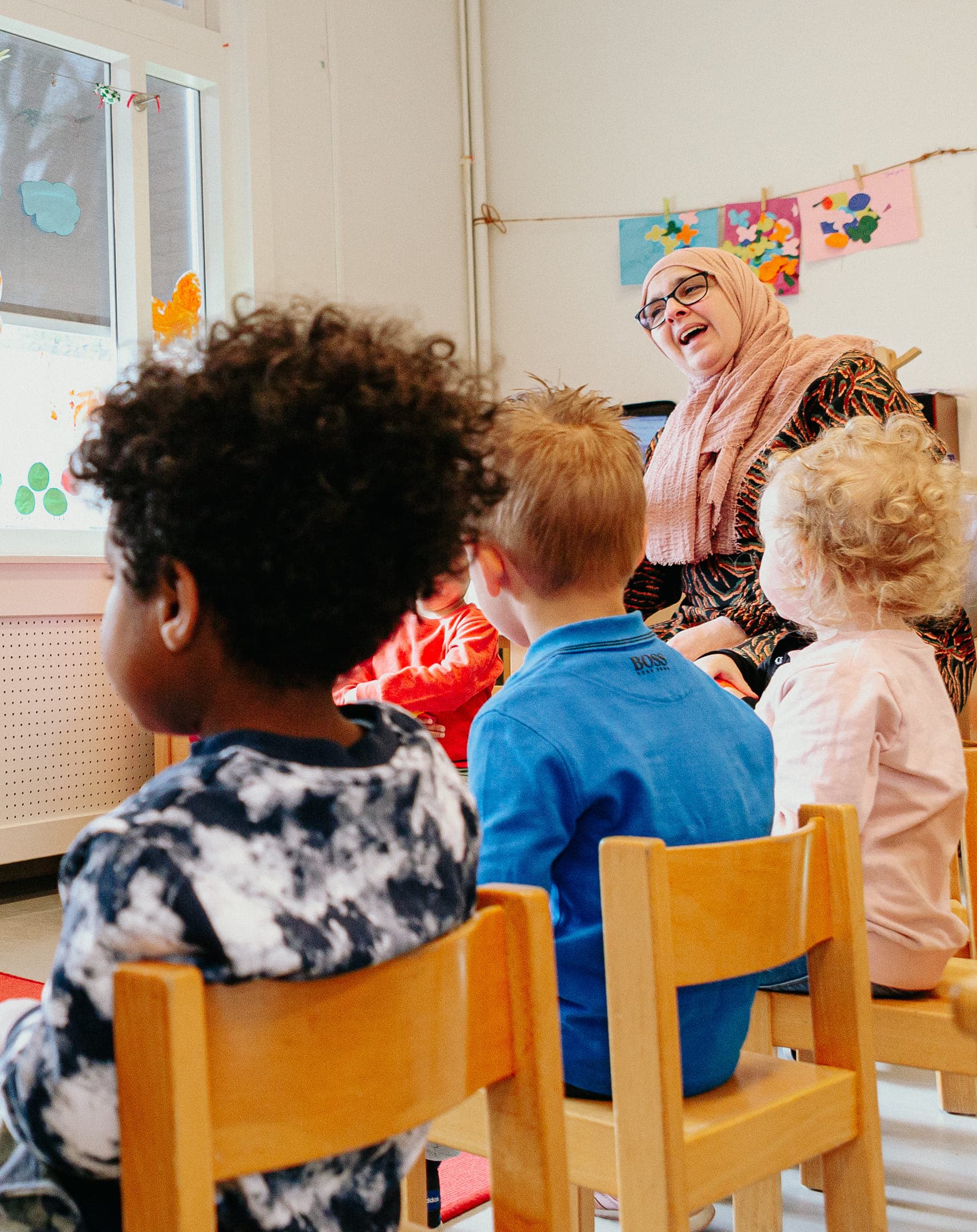 Kinderen zitten in kring bij Kind&co ludens