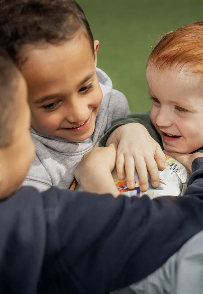 Kinderen spelen een bal en lachen met elkaar bij kinderopvang Kind&co ludens