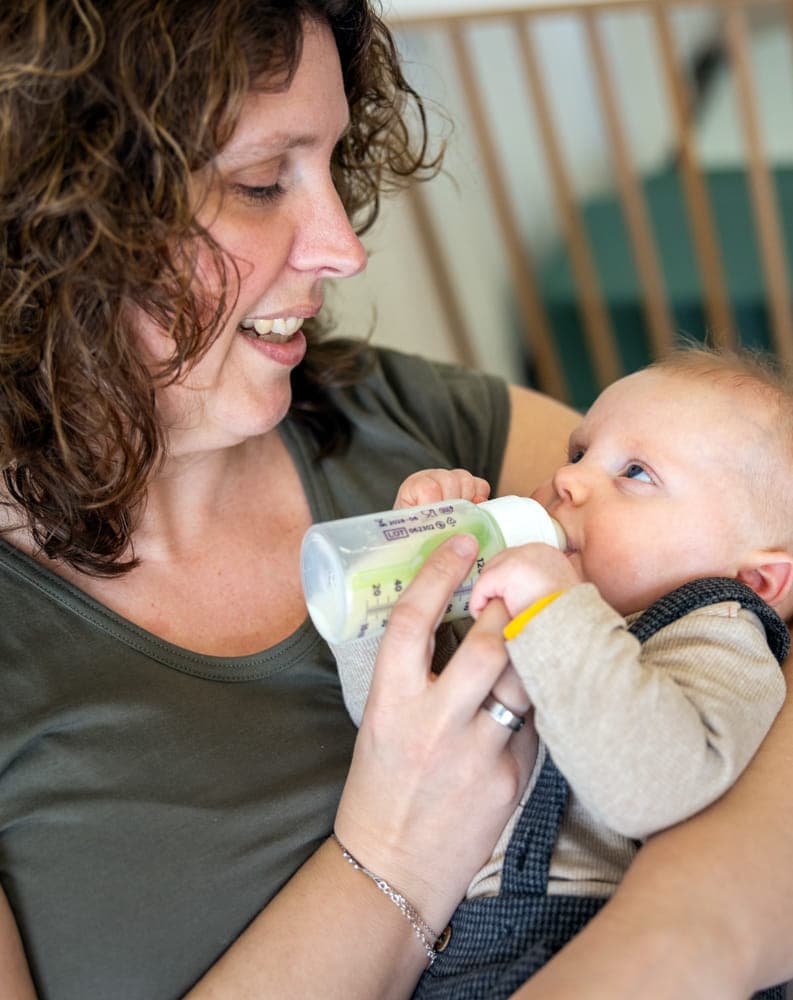 Baby krijgt een fles bij kinderopvang Kind&co ludens
