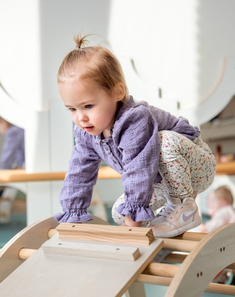 Kind klimt op klimrekje bij kinderopvang Kind&co ludens
