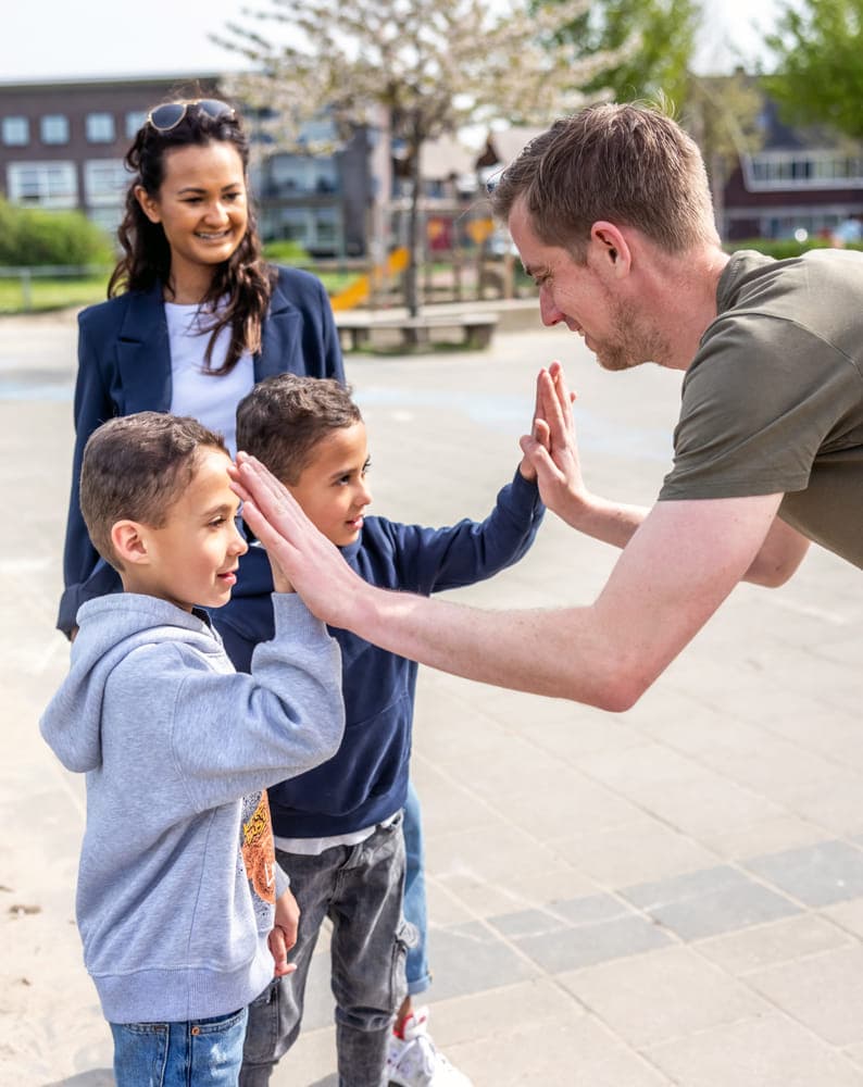 Pedagogisch medewerker geeft een high five bij kinderopvang Kind&co ludens