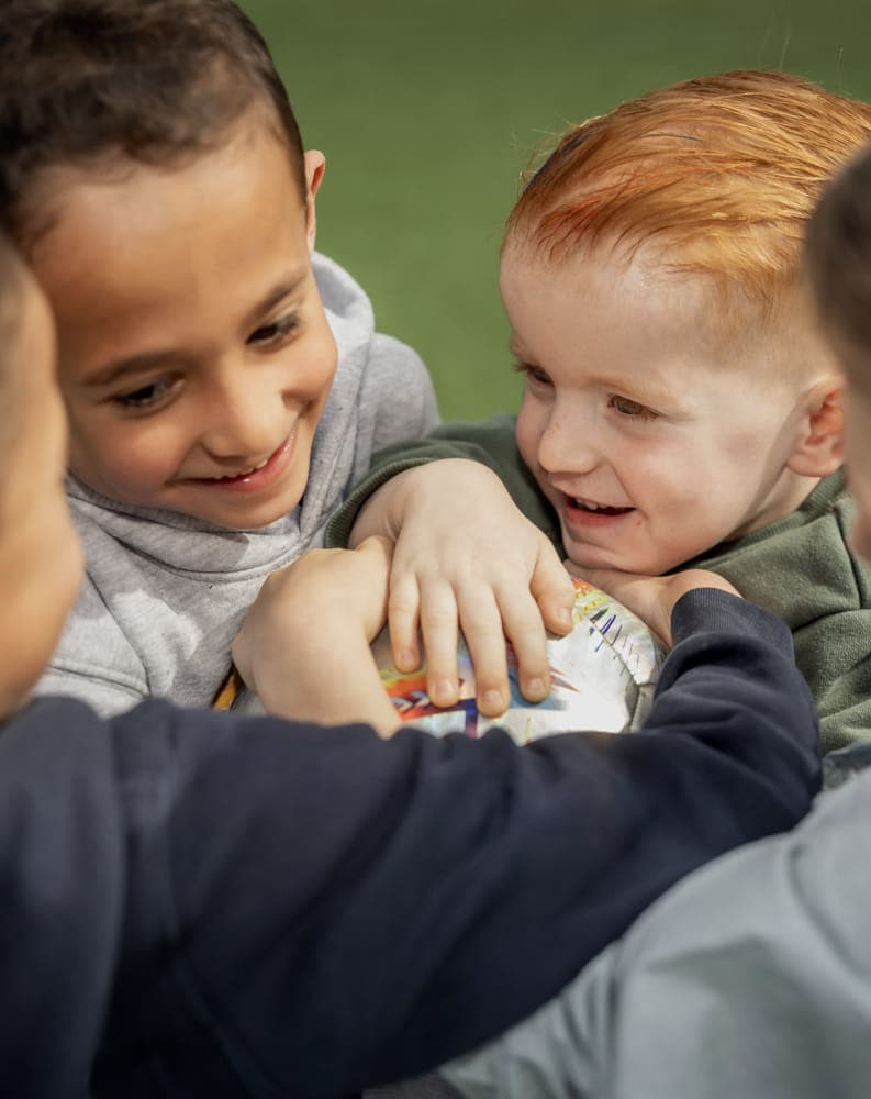 Kinderen spelen een bal en lachen met elkaar bij kinderopvang Kind&co ludens