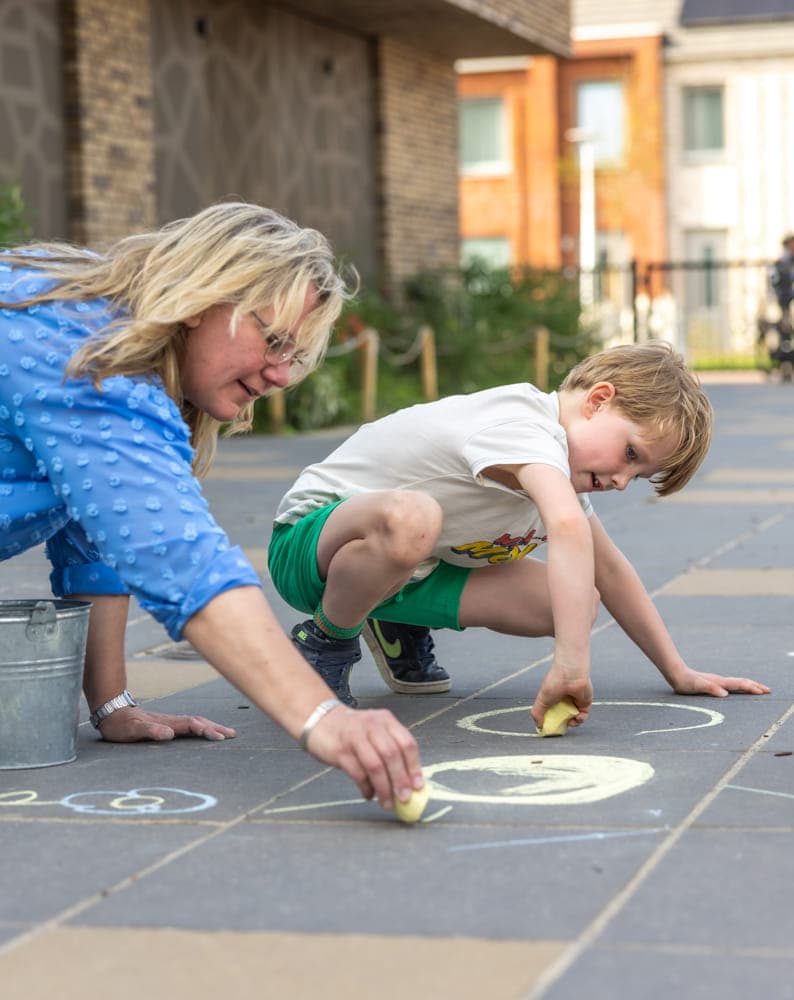 Kinderen stoepkrijten samen bij kinderopvang Kind&co ludens