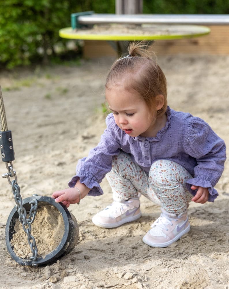 Kind speelt buiten bij kinderopvang Kind&co ludens