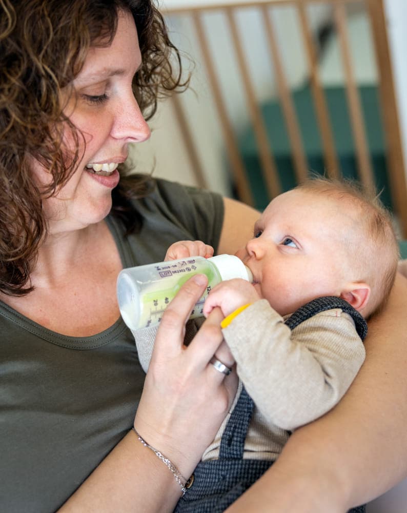 Baby krijgt een fles bij kinderopvang Kind&co ludens