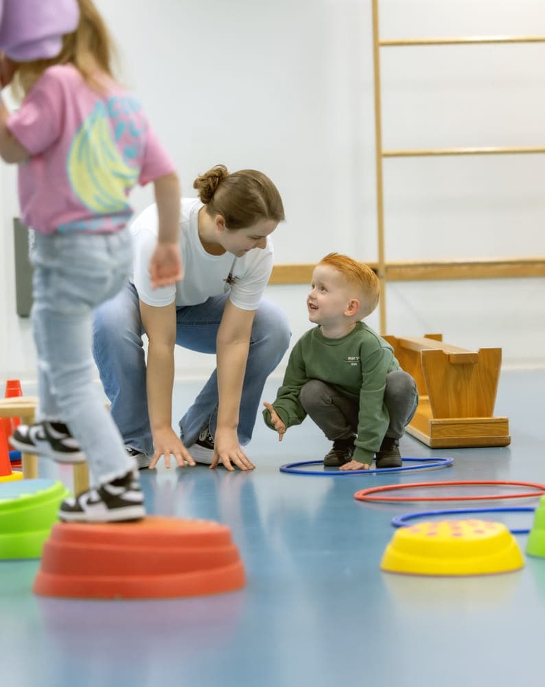 kinderen worden begeleid door pedagogisch medewerkers met het binnenspelen in de gymzaal bij kinderopvang Kind&co ludens