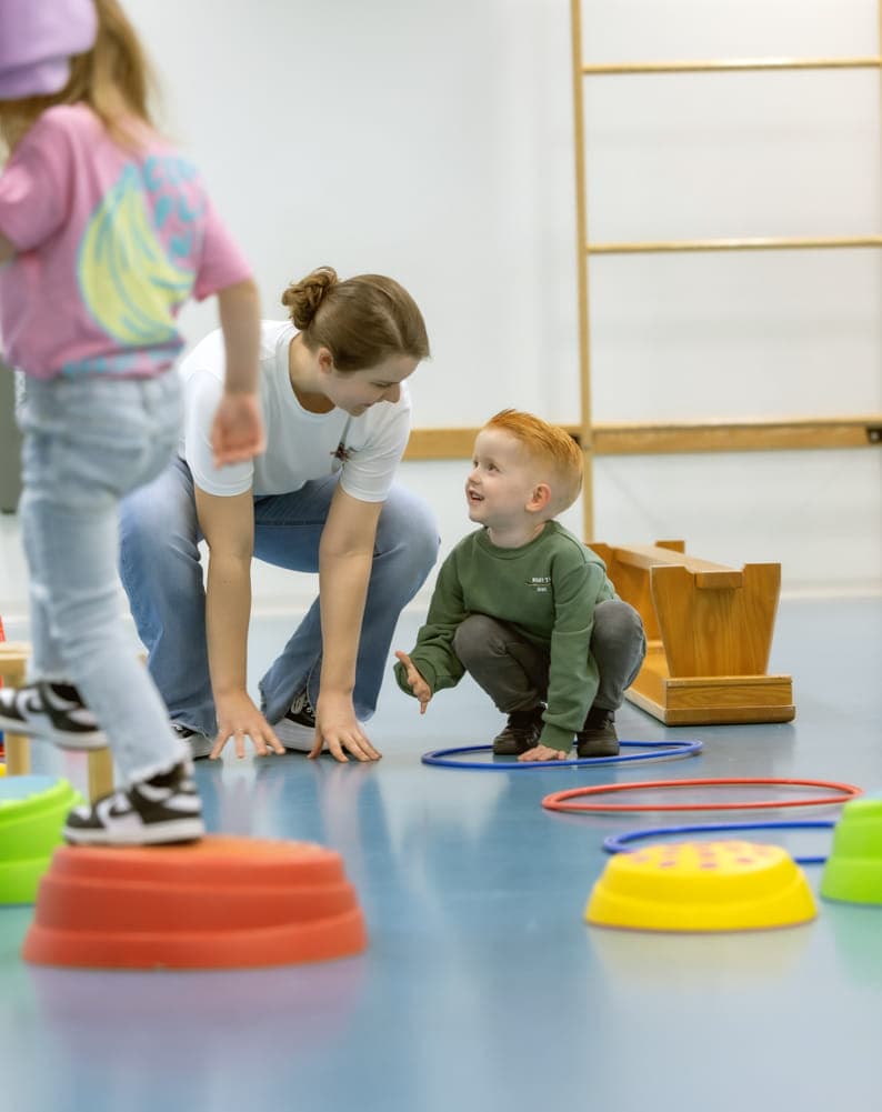 kinderen worden begeleid door pedagogisch medewerkers met het binnenspelen in de gymzaal bij kinderopvang Kind&co ludens