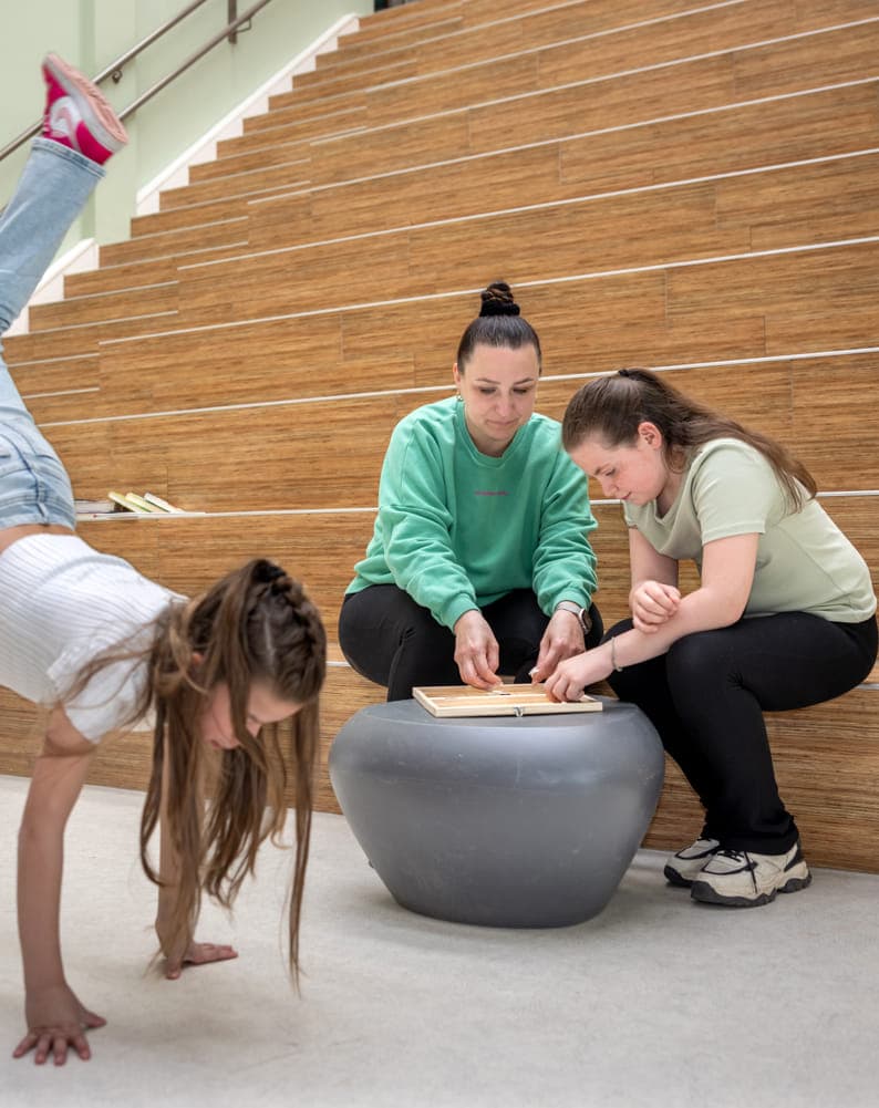 kinderen spelen in de hal in aanwezigheid van een pedagogisch medewerker bij kinderopvang Kind&co ludens