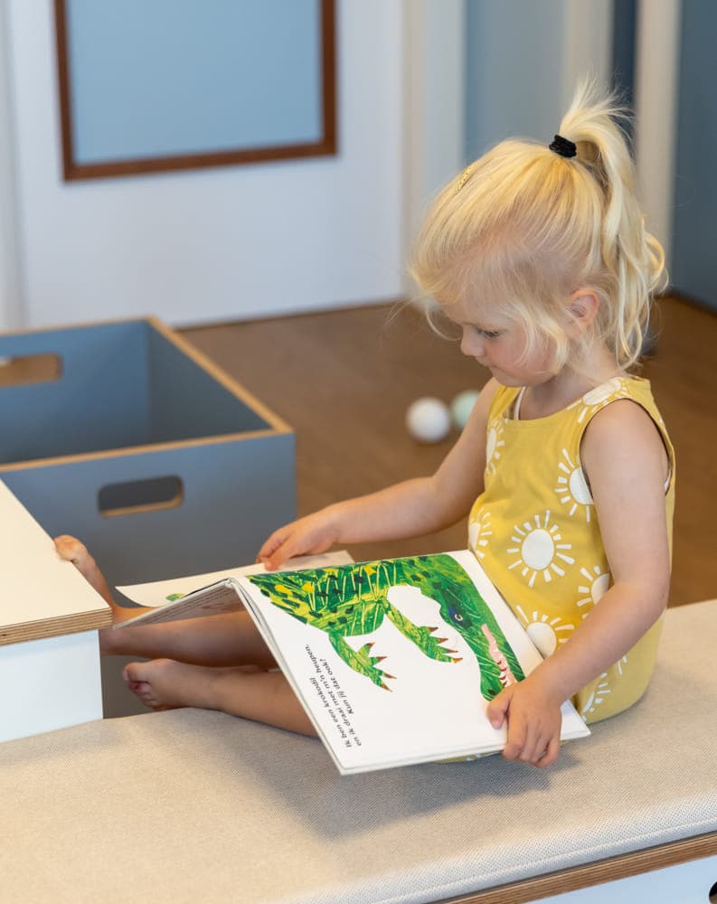 Kind leest een boek bij kinderopvang Kind&co ludens