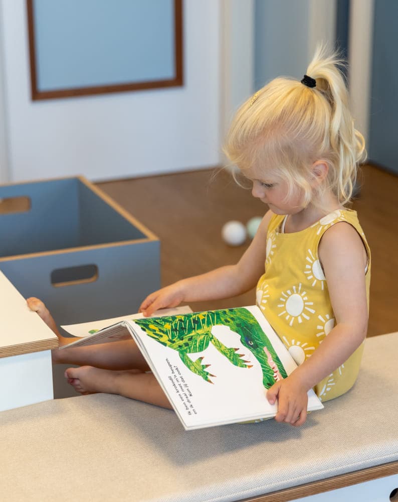 Kind leest een boek bij kinderopvang Kind&co ludens