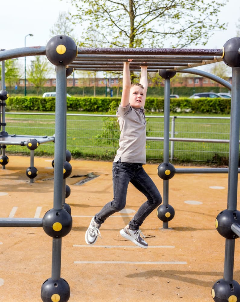 Kinderen spelen buiten in klimrek bij kinderopvang Kind&co ludens