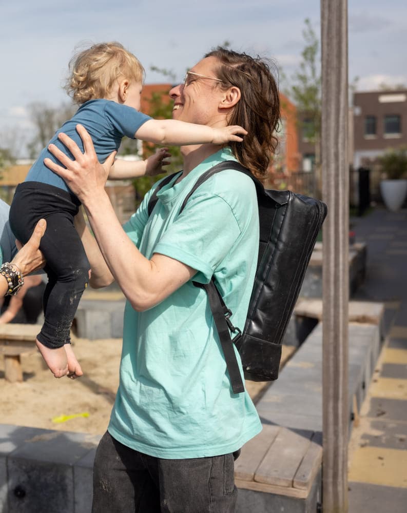 Pedagogisch medewerker geeft overdracht aan ouder bij kinderopvang Kind&co ludens