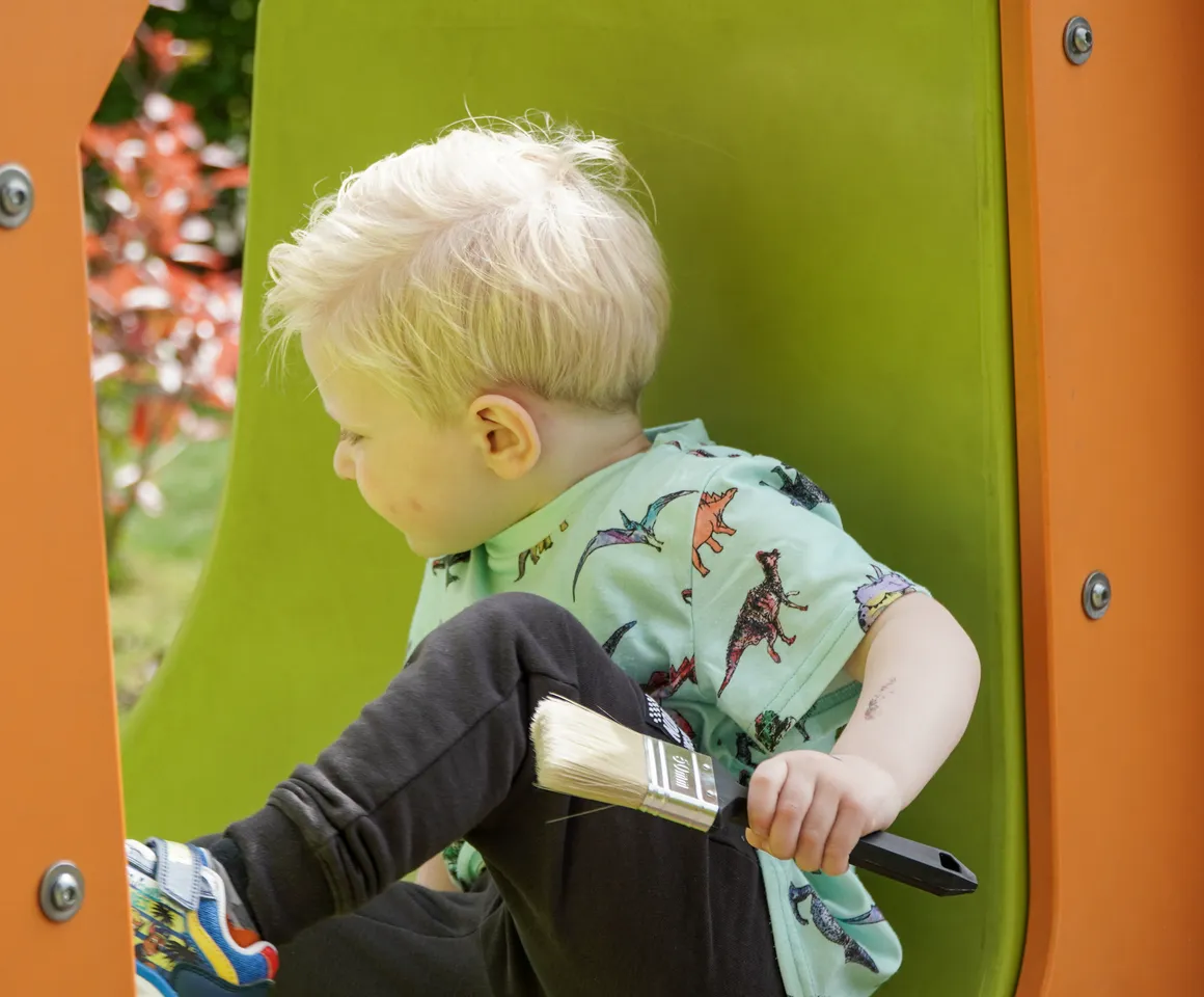 Kind speelt buiten op speeltoestel bij gastouder van kinderopvang Kind&co ludens