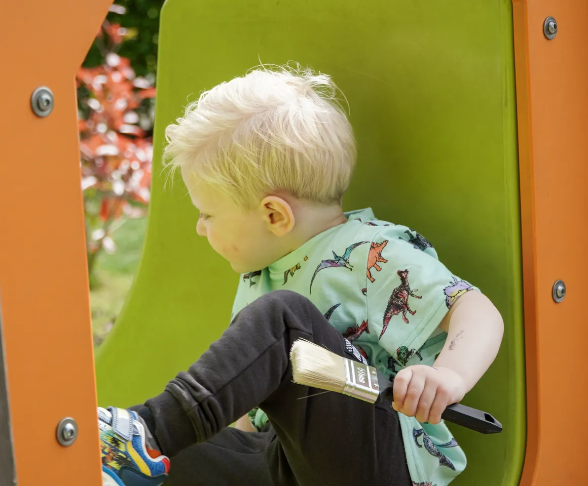 Kind speelt buiten op speeltoestel bij gastouder van kinderopvang Kind&co ludens