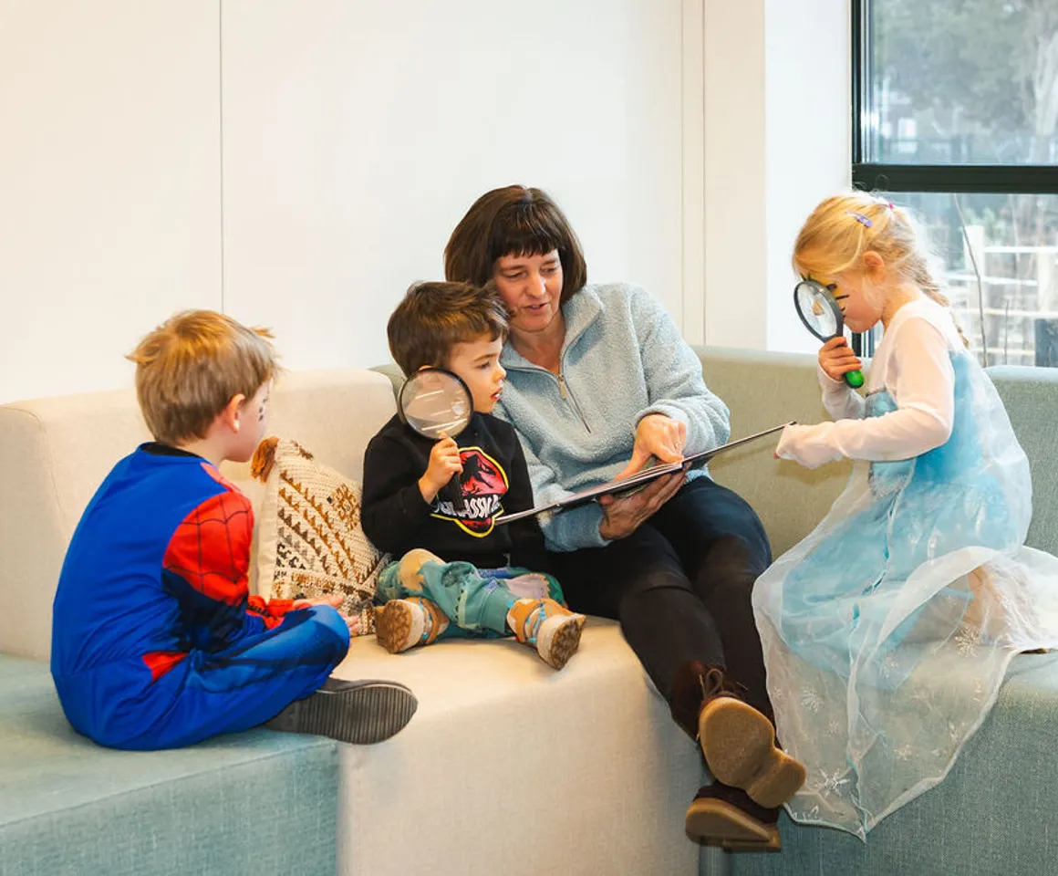 Pedagogisch medewerker leest boek voor bij BSO Kikkersloot van Kind&co ludens