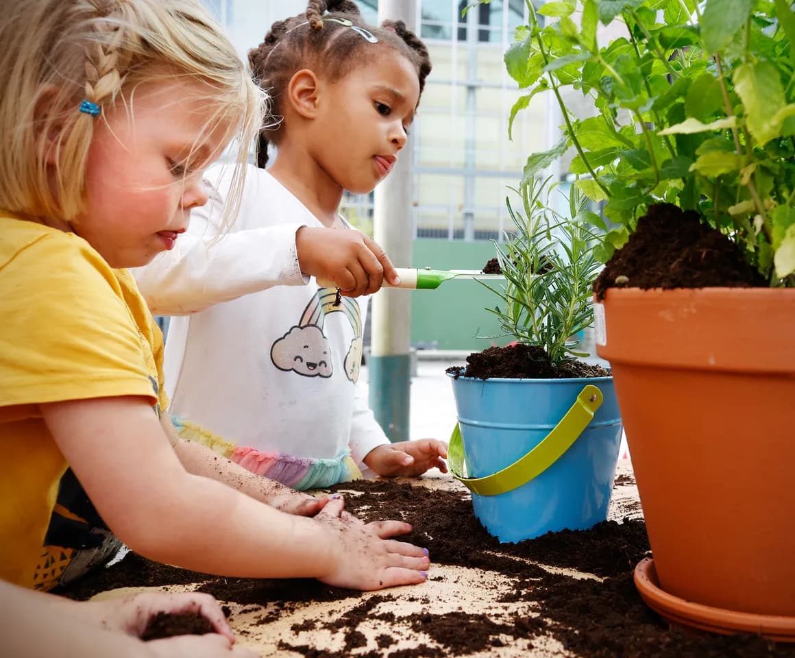 Kinderen van de peutergroep tuinieren in de moestuin bij kinderopvang Kind&co ludens