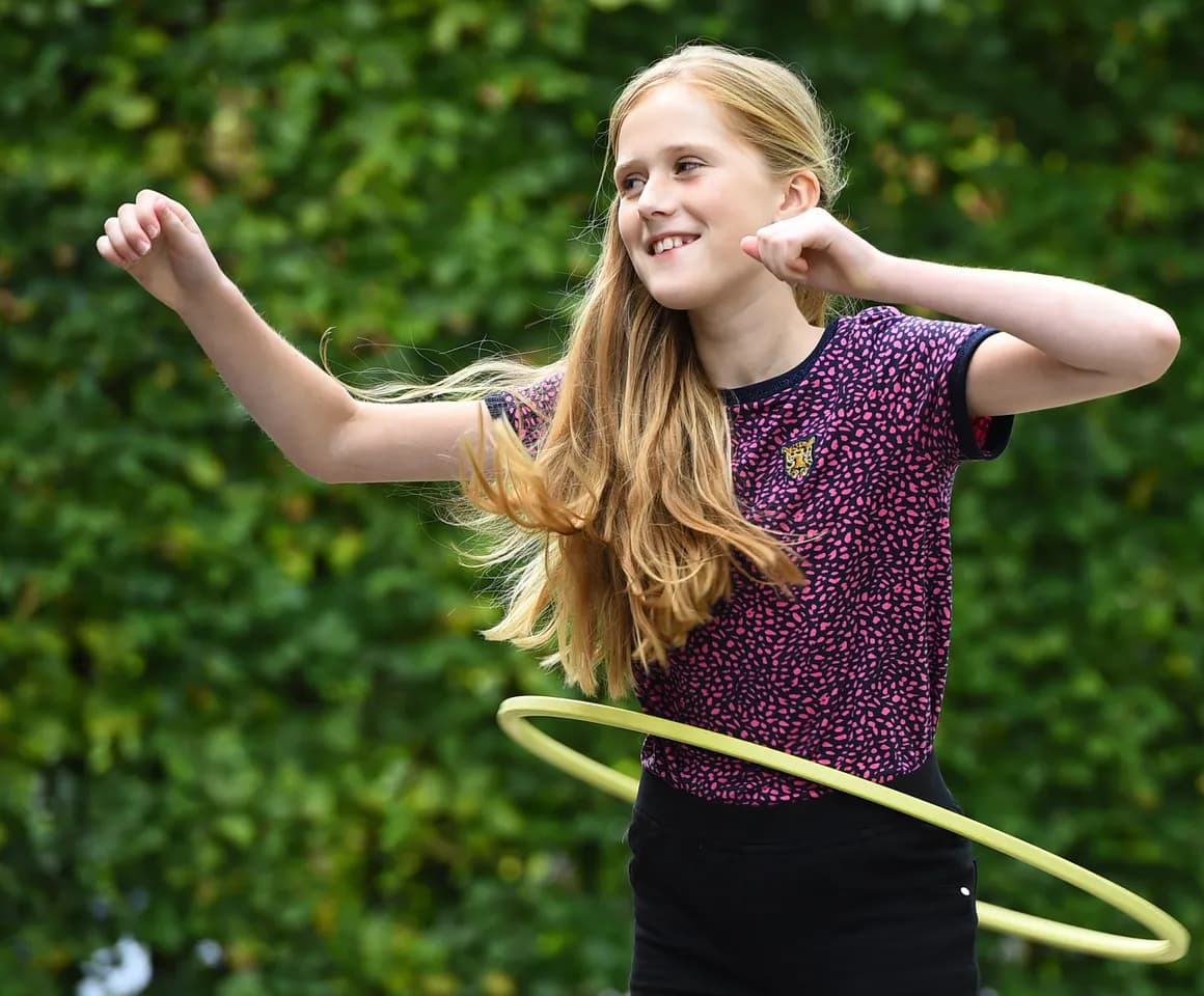 Kind van de BSO hoepelt buiten bij kinderopvang Kind&co ludens